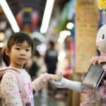 photo of girl laying left hand on white digital robot