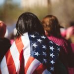 woman with US American flag on her shoulders