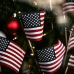 USA flaglet beside green Christmas tree